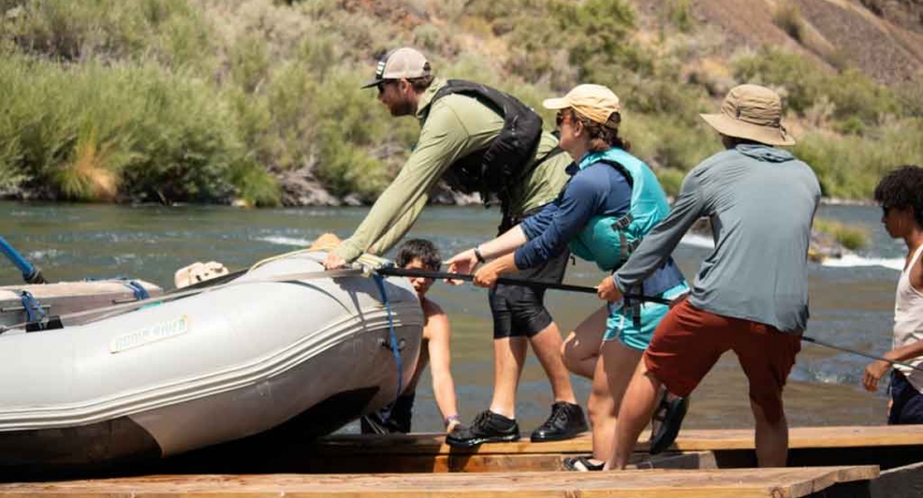 a group of students pull a raft onto a trailer during a gap year semester with outward bound